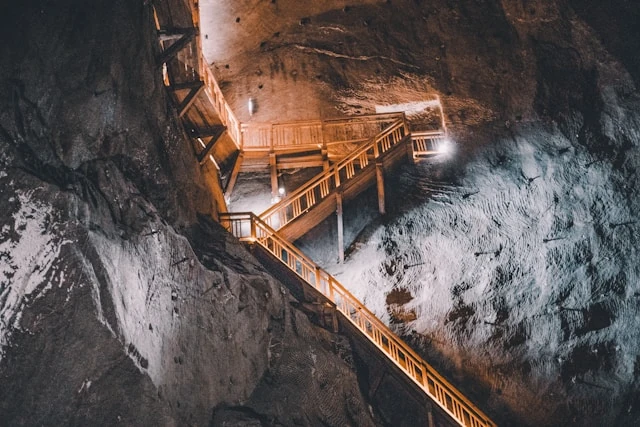 Long wooden staircase descending into an underground section of a Sierra Leone iron ore mine, similar to the Tonkolili Project.